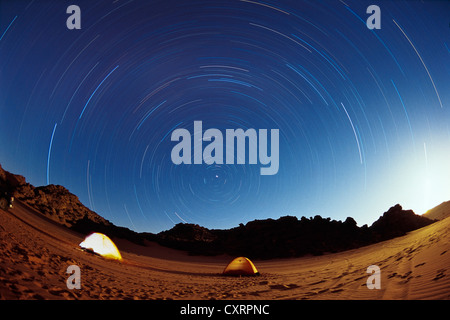 Tents under a starry sky in the Libyan Desert, star trails, Wadi Awis, Acacus Mountains, Libya, Sahara, Africa Stock Photo