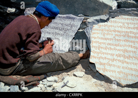 Tibetan Buddhist mantras carved in stone by man, Tongde Monastery, Zanskar Valley, Zanskar, Ladakh, Jammu and Kashmir Stock Photo