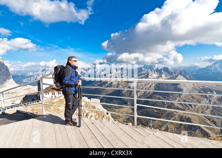 Male tourist, 55, enjoying the view from the deck of the Rifugio Lagazuoi mountain inn, 2752 m, Falzarego Pass, Dolomites, Italy Stock Photo