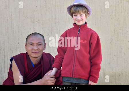 Monk holding the hand of a European child, 6 years, Labrang Monastery, Xiahe, Gansu, formerly Amdo, Tibet, China, Asia Stock Photo