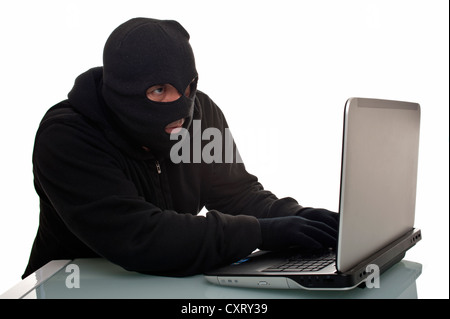 Hacker surfing the internet with a laptop computer, symbolic image for computer hacking, computer or cyber crime, data theft Stock Photo