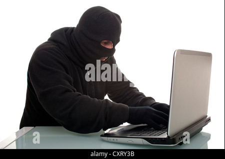 Hacker surfing the internet with a laptop computer, symbolic image for computer hacking, computer or cyber crime, data theft Stock Photo