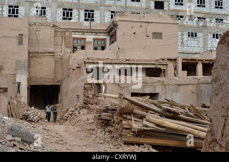 Two Uyghur boys in the ruins of the old adobe brick houses of Kashgar, large-scale destruction of the Uyghur old town of the Stock Photo