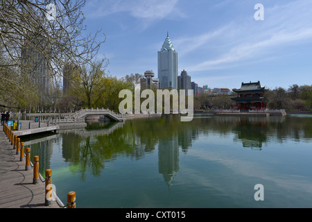 Lake in the Volkspark public park in front of skyscrapers and a Chinese pavilion, Urumqi, capital district, Uyghur, Silk Road Stock Photo