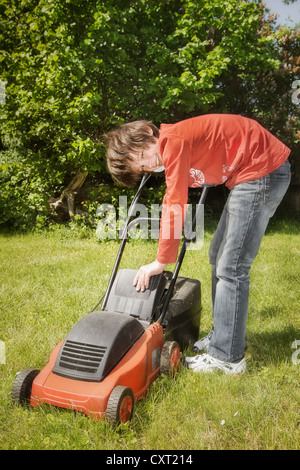 Boy with a lawnmower Stock Photo