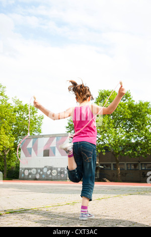 Girl skipping rope in the school playground Stock Photo