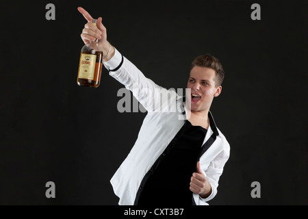 Young man holding a bottle of whiskey Stock Photo