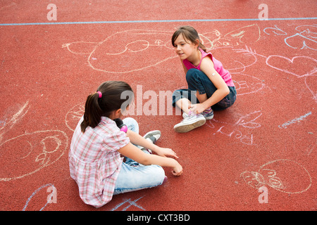 Two girls sitting around bored on the school playground Stock Photo