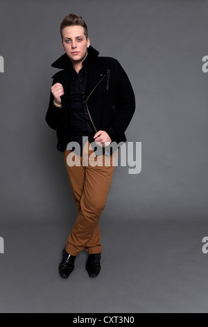 Young man in a black jacket and brown trousers Stock Photo