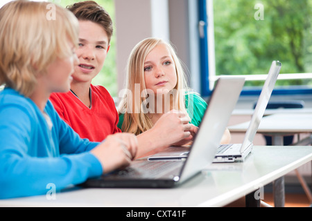 Group of schoolchildren working with laptops in a classroom Stock Photo