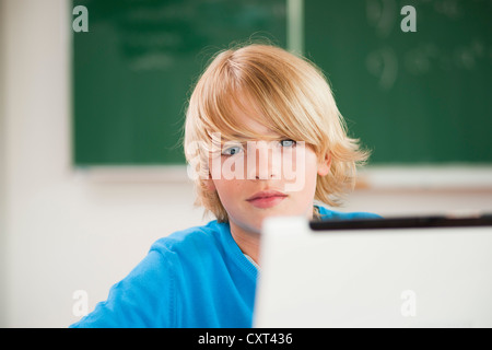 Schoolboy using a laptop in a classroom Stock Photo