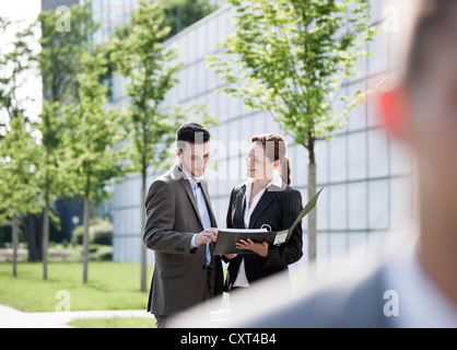 Colleagues talking in front of an office building Stock Photo
