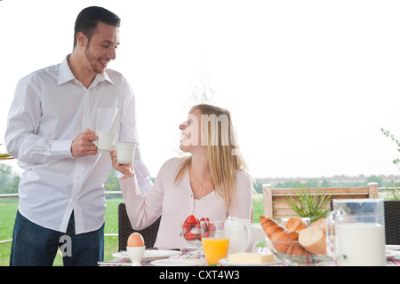 Young couple having breakfast on a terrace Stock Photo