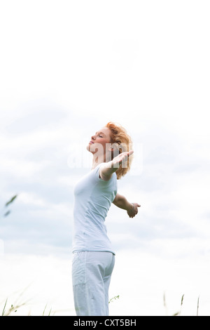 Young woman standing with outstretched arms Stock Photo