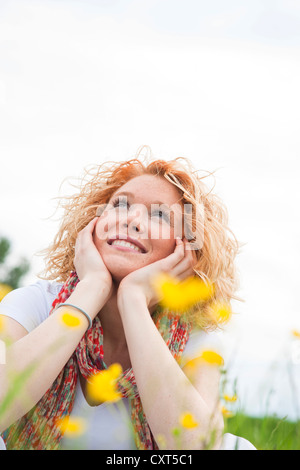 Young woman looking cheerfully upward Stock Photo