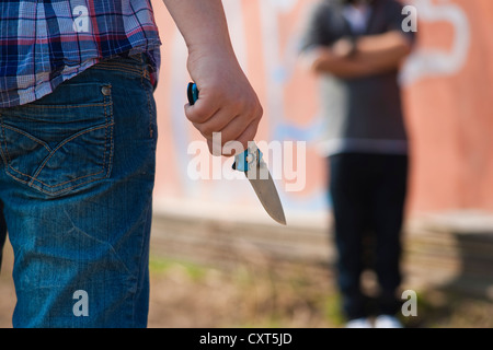 Boy is threatened by a youth with a knife Stock Photo