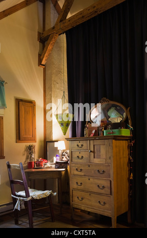 Antique chair, desk, dresser and furnishings in the upstairs bedroom of an old Canadiana cottage-style residential log home, Stock Photo