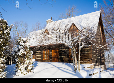 Old reconstructed Canadiana cottage-style residential log home, 1975, in winter, Quebec, Canada. This image is property released Stock Photo