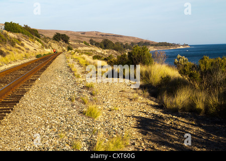 A couple strolls on a railroad track along the coast west of "Santa Barbara", California Stock Photo