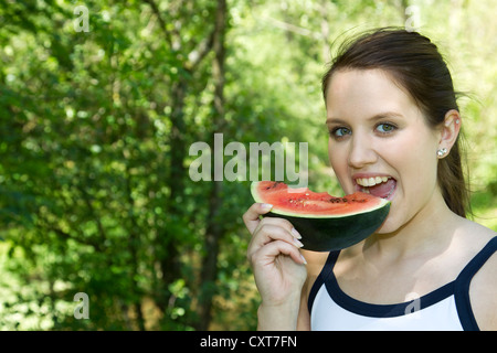 Young woman biting into a piece of watermelon Stock Photo