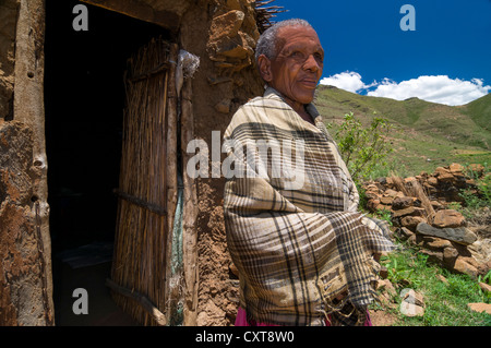 Old Basotho woman wearing a traditional dress standing in front of a hut, Drakensberg, Kingdom of Lesotho, southern Africa Stock Photo