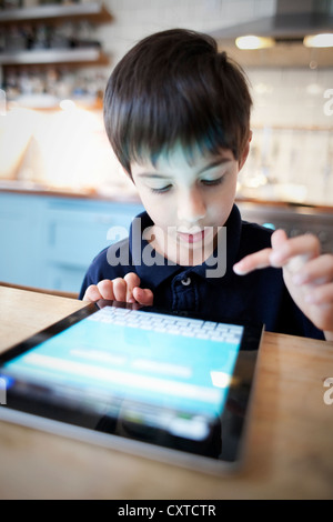 Boy using digital tablet on table, close up Stock Photo