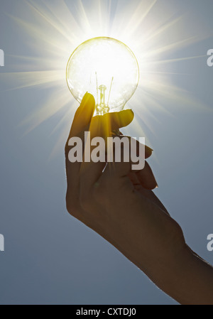 Close up of hand holding light bulb Stock Photo