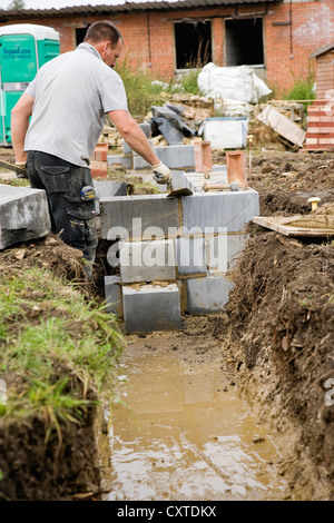 Bricklayer using Trowel when building concrete block Wall Stock Photo