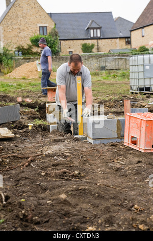 Workman using spirit level on concrete block in a UK construction Site Stock Photo