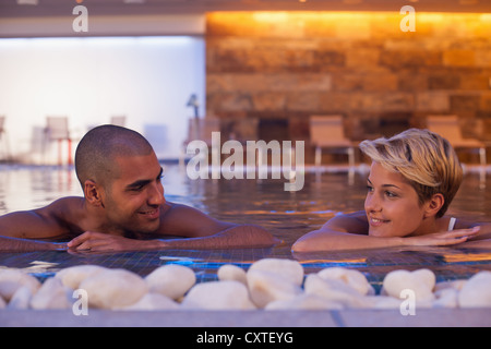 Couple relaxing in modern indoor pool Stock Photo