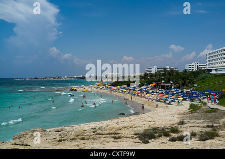 dh  AYIA NAPA CYPRUS SOUTH Bathers sandy beach coast and holiday resort hotels bay agia beaches Stock Photo