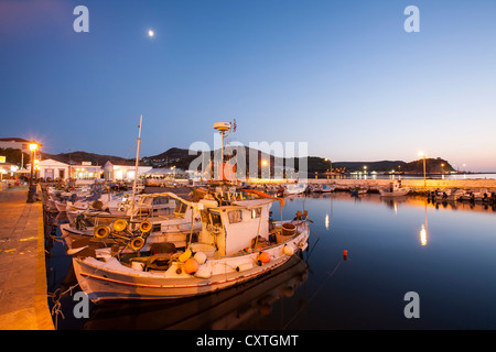 Traditional small Greek fishing boats in Myrina on Lemnos, Greece and harbourside tavernas. Stock Photo