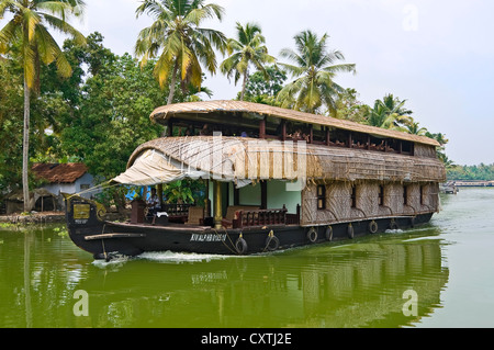 Horizontal view of a huge traditional wooden house boat, kettuvallam, sailing through the backwaters of Kerala. Stock Photo