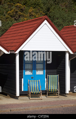 Two empty deckchairs outside beach hut at Bournemouth in September Stock Photo