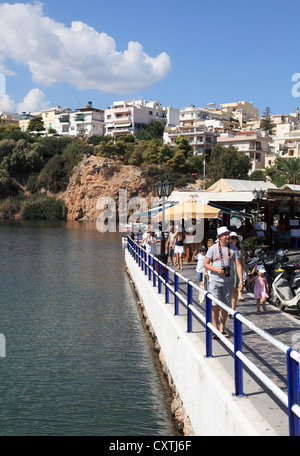 Tourists walking past the salt lake in Agios Nikolaos  Crete Greece Stock Photo