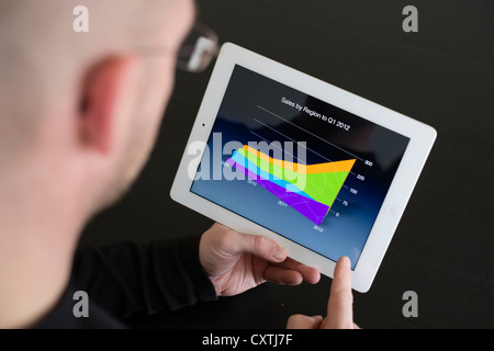Man preparing business presentation with charts on iPad3 tablet computer Stock Photo