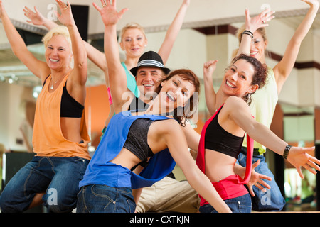 Zumba or Jazzdance - young people dancing in a studio or gym doing sports or practicing a dance number Stock Photo