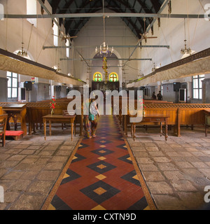 Vertical interior view of tourists walking around St Francis Church in Fort Cochin in Kerala. Stock Photo