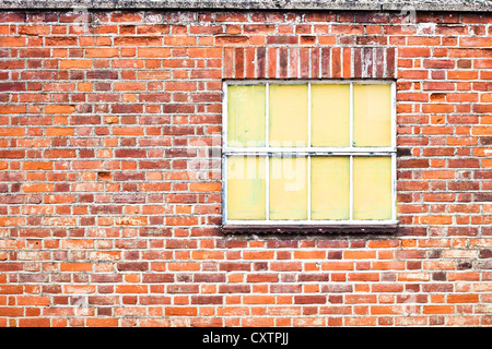 Old window in a brick wall painted over Stock Photo
