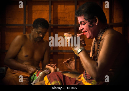 Horizontal close up portrait of Kathakali performance artists applying make up before their performance. Stock Photo