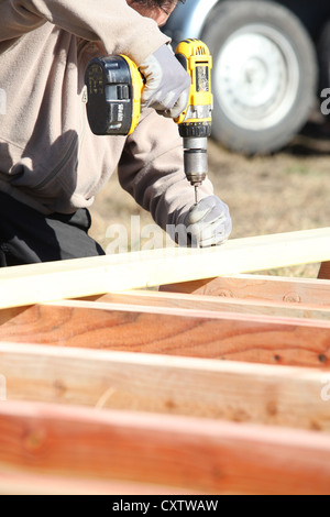 Builder using a cordless drill Stock Photo