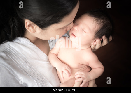 Mother tenderly holding her newborn baby (5 days old) Stock Photo