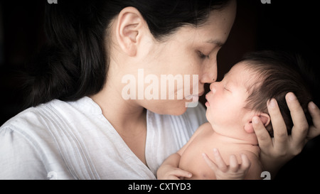 Mother tenderly holding her newborn baby (5 days old) Stock Photo