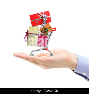 Hand holding a shopping cart full of gift boxes isolated on white background