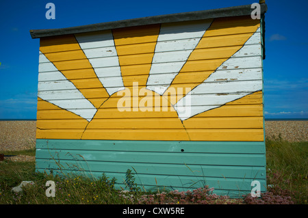 Small beach hut with a sun painted on its side New Romney Kent UK Stock Photo