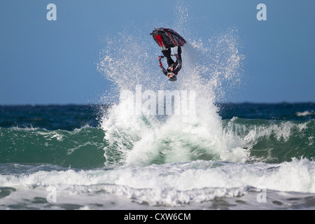 Freeriding Jetski doing an inverted jump off a wave at Fistral Beach in Newquay, Cornwall, UK Stock Photo