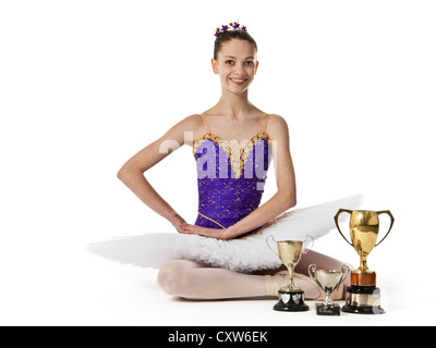 Teenage ballerina in purple and white tutu with festival competition trophies Stock Photo