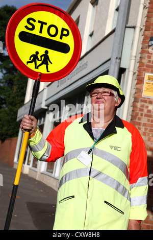 A lollipop lady on a school crossing patrol in the U.K. Stock Photo