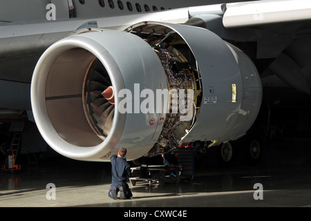 A technician carries out maintenance on a Rolls-Royce Trent 500 aircraft jet engine. Aviation engineering, knowledge workers, skilled workforce. Stock Photo
