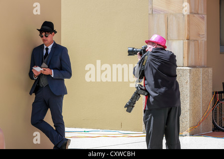 Media photographer takes a picture of a young man dressed in 1920s retro suit Stock Photo